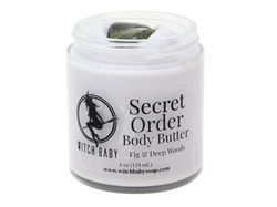2 oz glass jar filled with light lavender colored body butter topped with labradorite. Clear label reads: Secret Order Body Butter. Fig & Deep Woods.